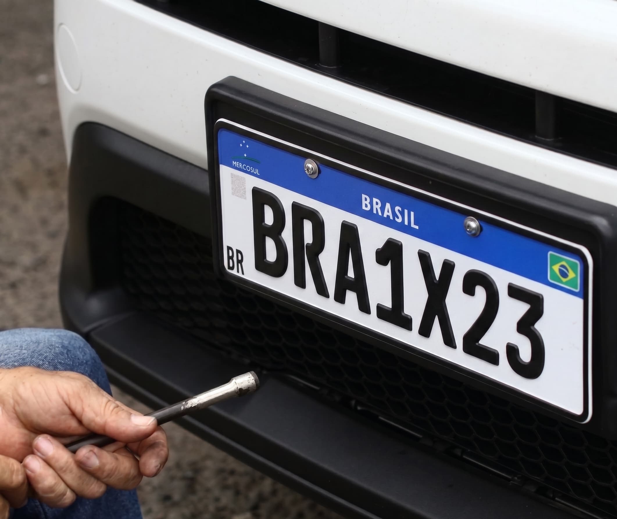 Instalação de placa Mercosul no para-choque de um veículo na Casa de Placas em Rio Negro